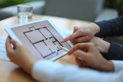 Real-estate,Agent,Showing,House,Plans,On,Electronic,Tablet
